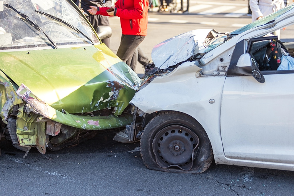 Severe two-car collision at urban intersection with significant damage to both vehicles